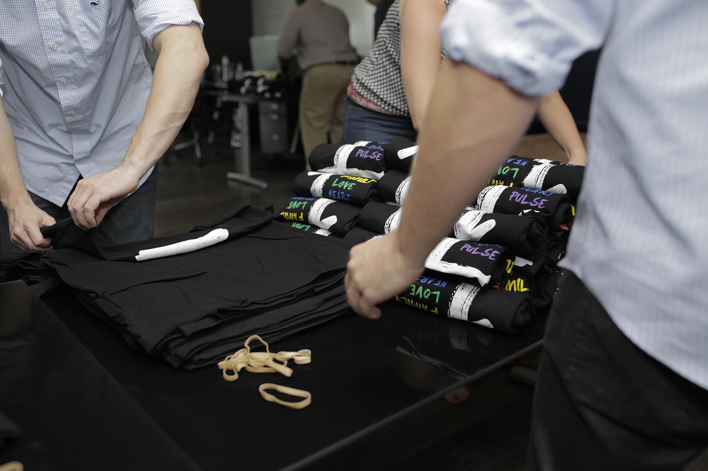Volunteers rolling fundraiser shirts